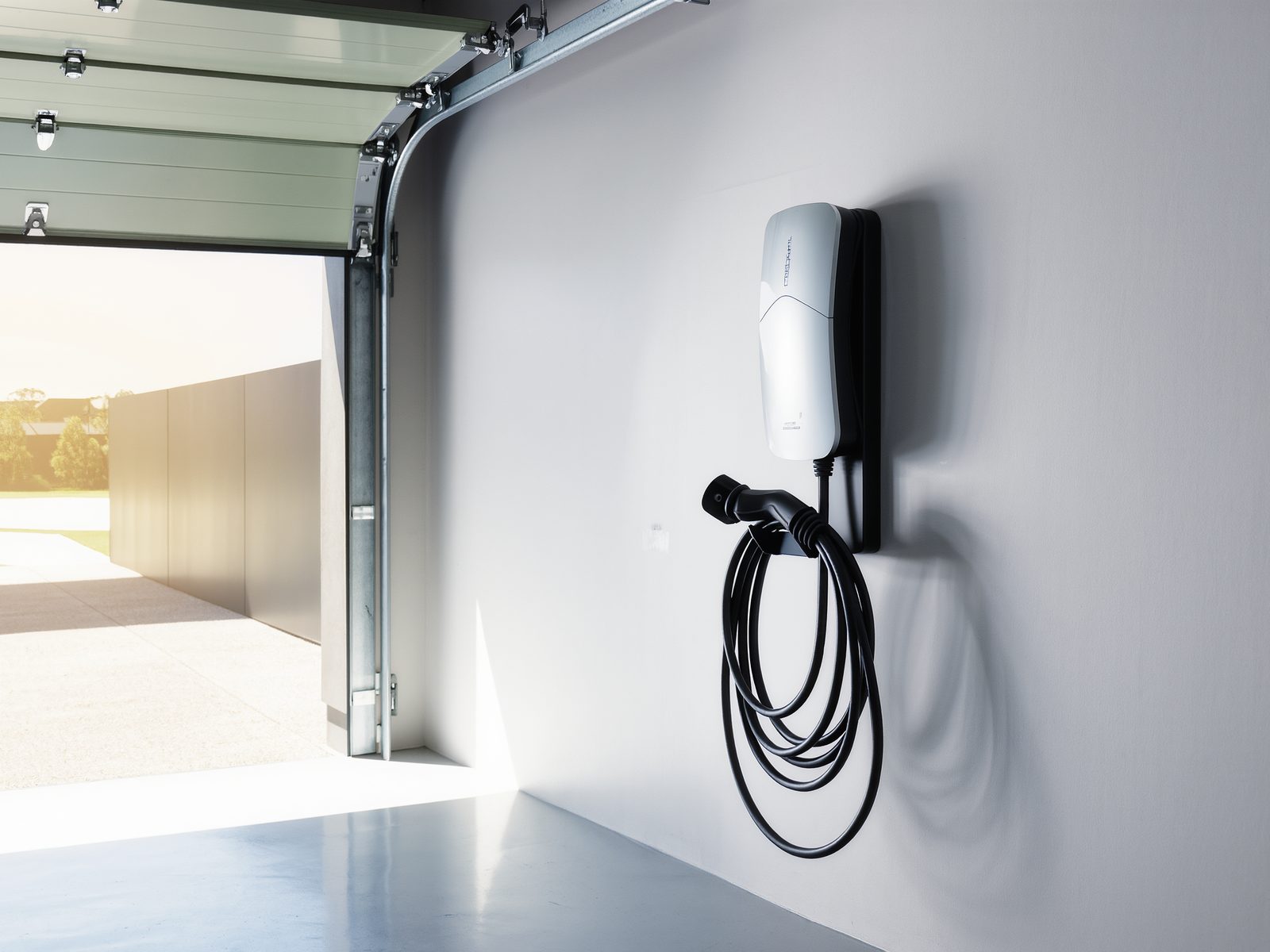 Wall-mounted EV charger with coiled cable in a garage